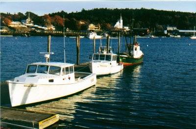 Boats at town pier and view of Our Lady Queen of Peace Catholic Church - Boothbay Harbor